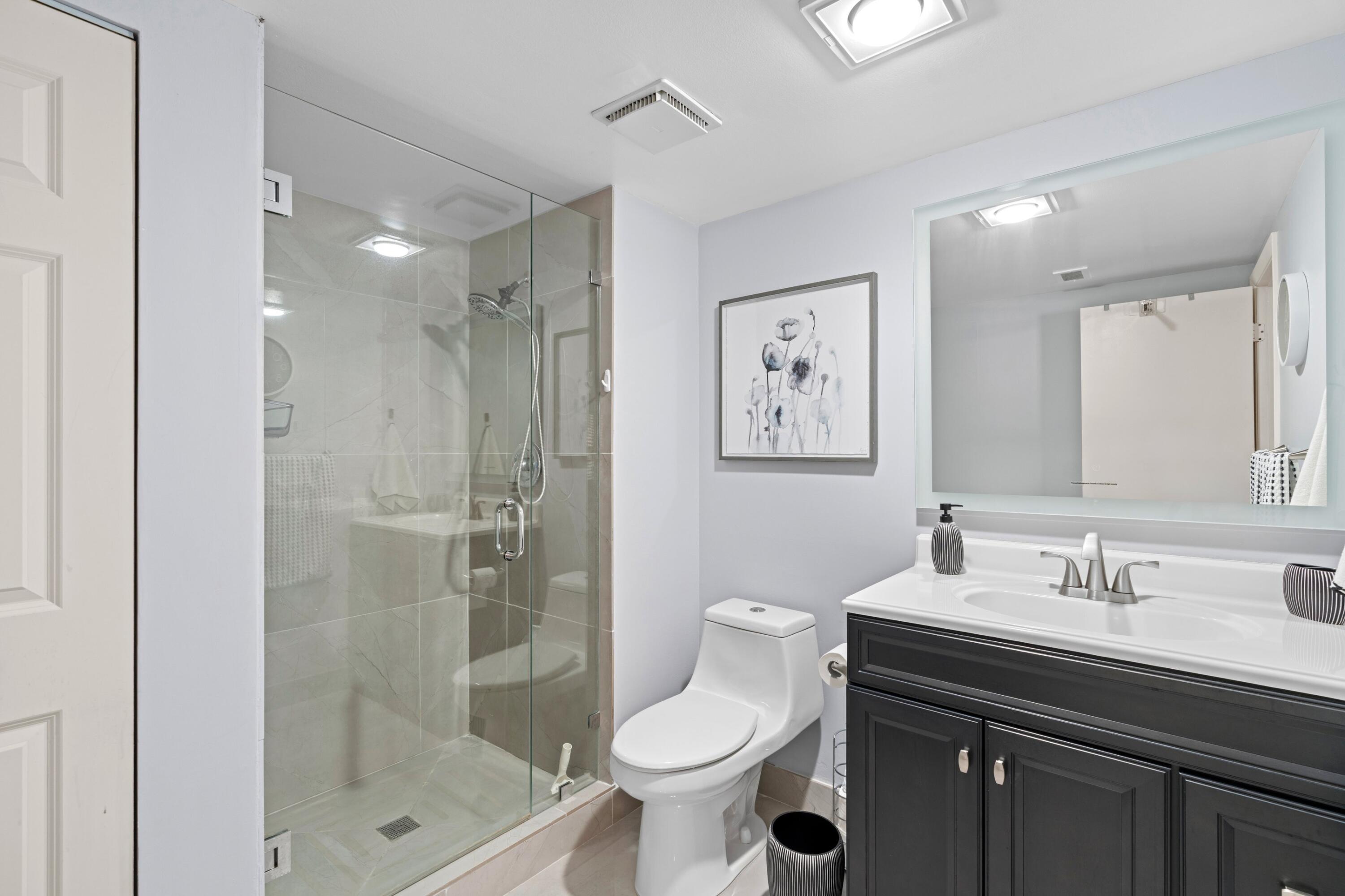 9265 Vista Del Lago, Unit 41B Boca Raton, FL 33428 - Photo 19 of 42 a bathroom with a sink toilet and shower