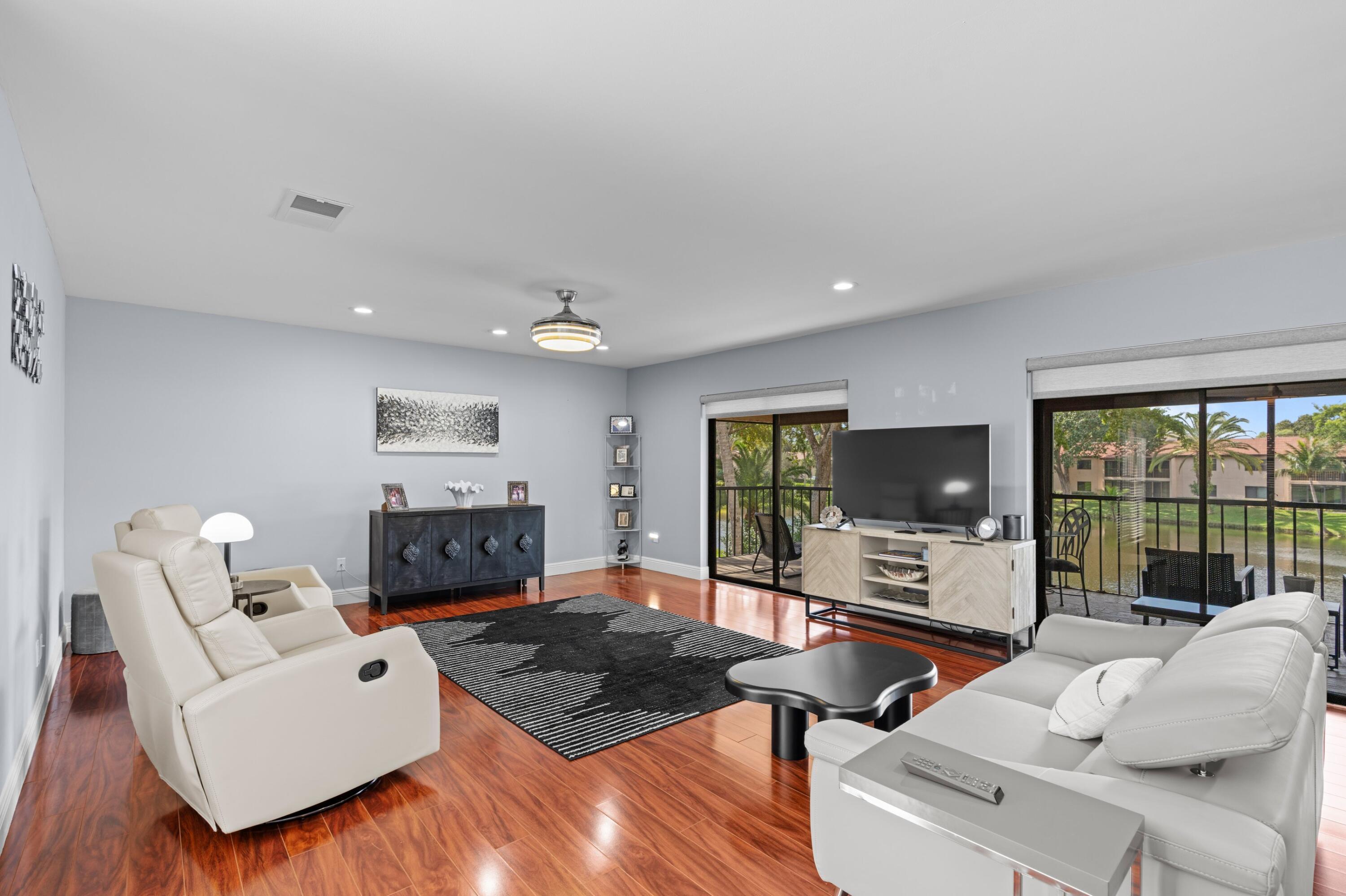 9265 Vista Del Lago, Unit 41B Boca Raton, FL 33428 - Photo 5 of 42 a living room with furniture a flat screen tv and a large window