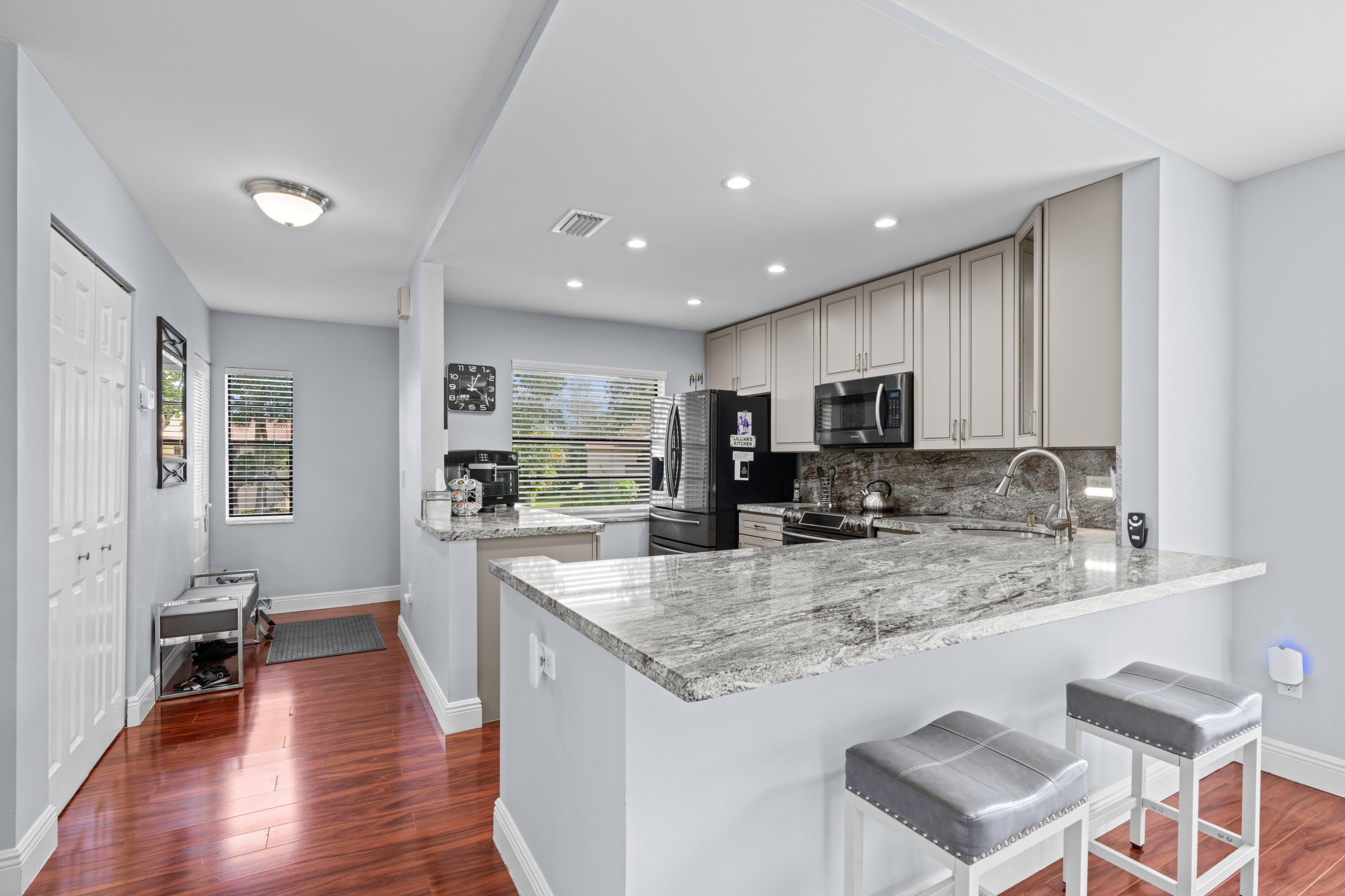 9265 Vista Del Lago, Unit 41B Boca Raton, FL 33428 - Photo 8 of 42 a kitchen with stainless steel appliances granite countertop a sink counter space and cabinets