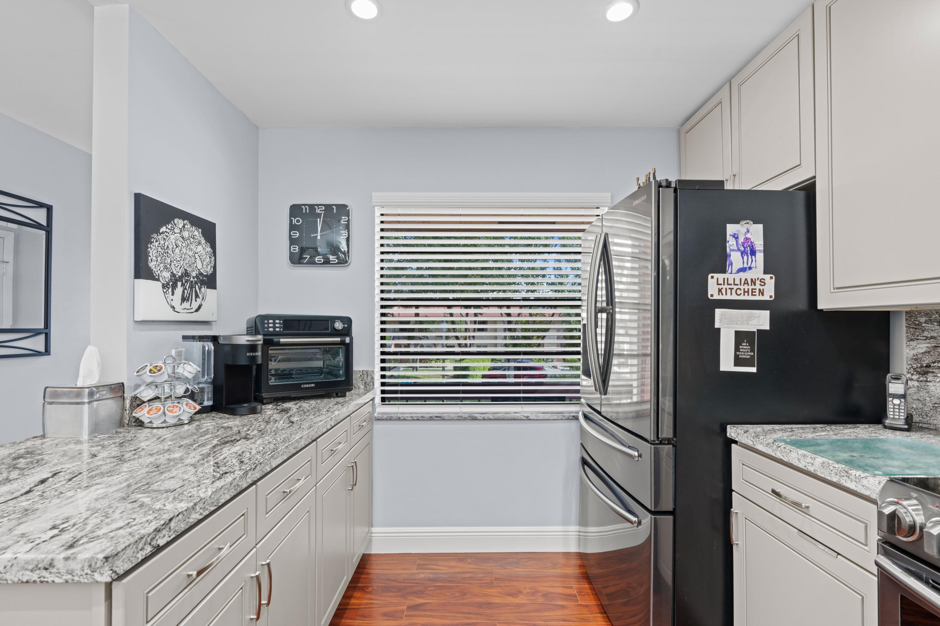 9265 Vista Del Lago, Unit 41B Boca Raton, FL 33428 - Photo 10 of 42 a kitchen with a refrigerator and a stove top oven