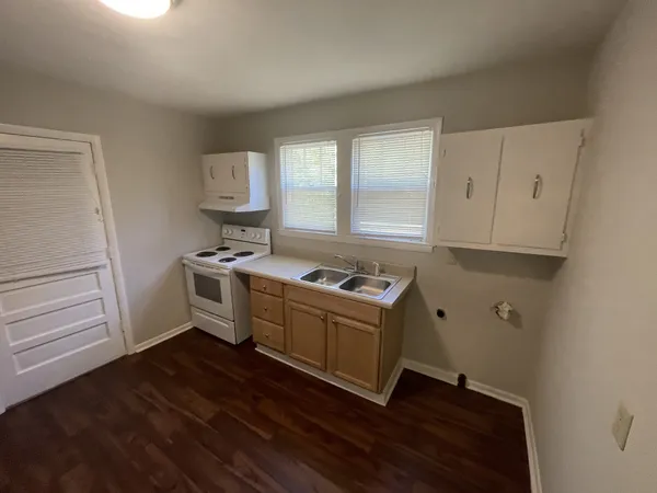 a kitchen with wooden floors and white appliances