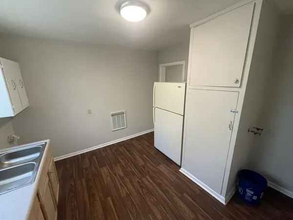 a view of kitchen with refrigerator and wooden floor