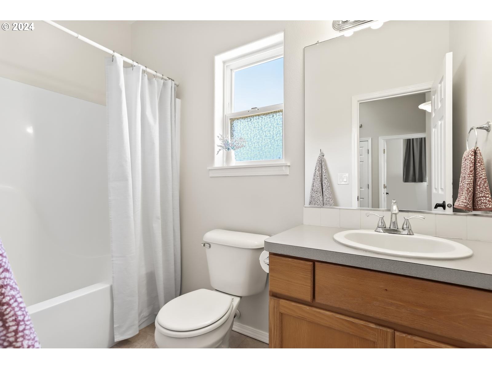 18283 Davis Street Sandy, OR 97055 - Photo 33 of 42 a bathroom with a sink a toilet a mirror and shower curtain