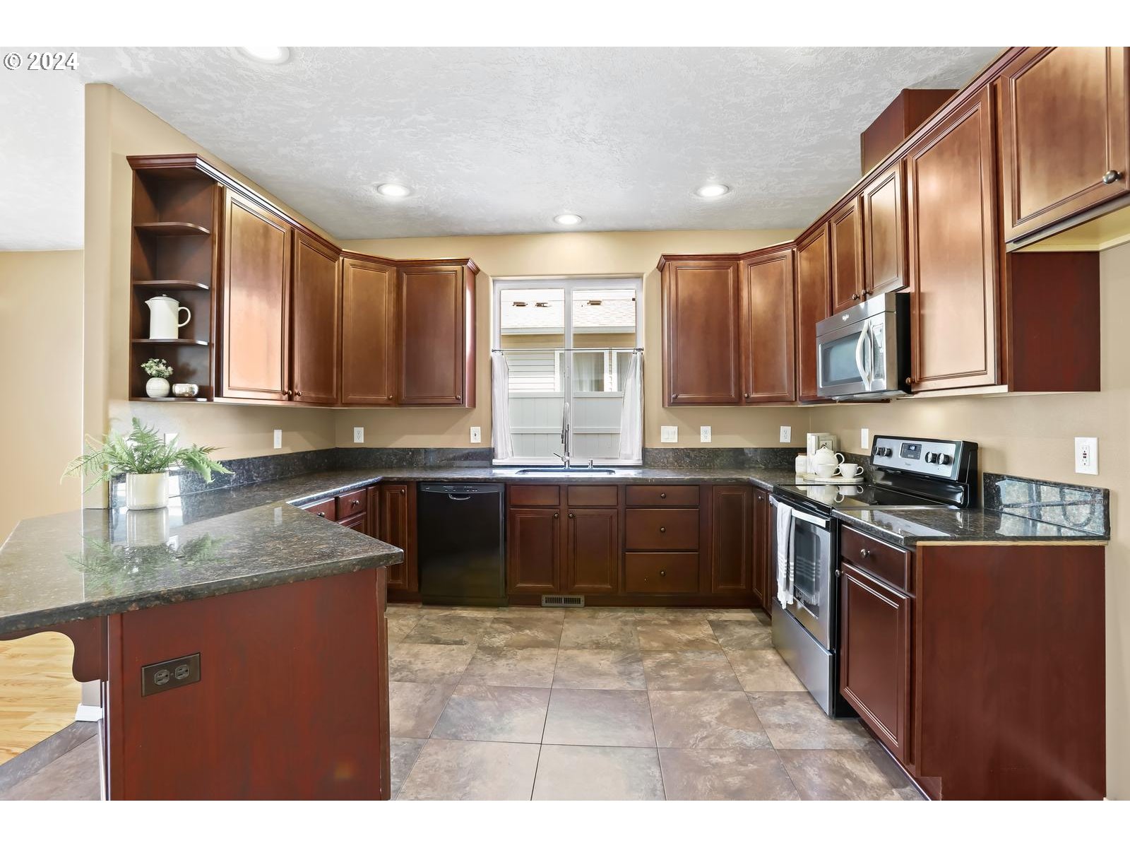 18283 Davis Street Sandy, OR 97055 - Photo 8 of 42 a kitchen with stainless steel appliances granite countertop wooden cabinets a stove top oven a sink and dishwasher