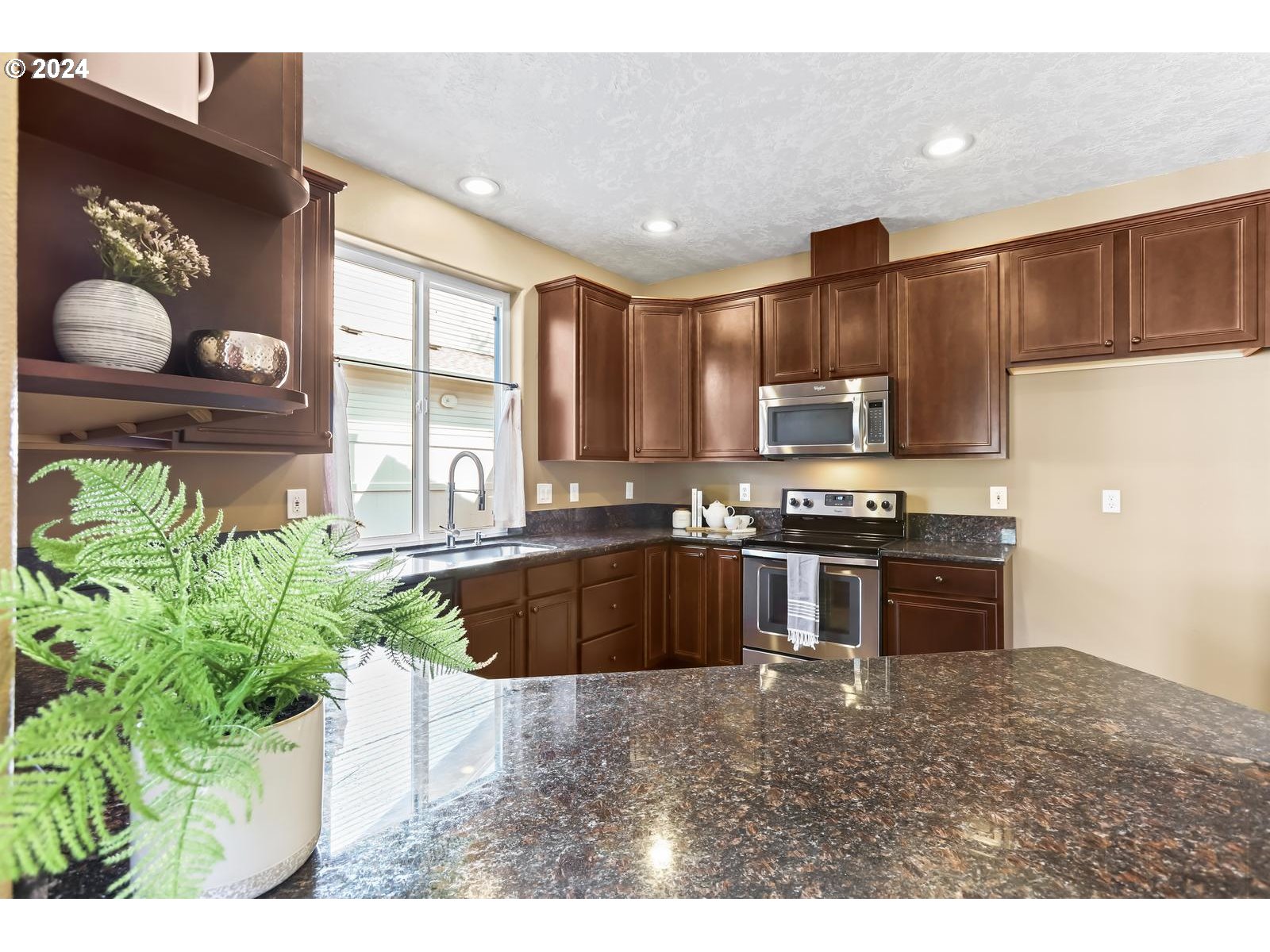 18283 Davis Street Sandy, OR 97055 - Photo 9 of 42 a kitchen with stainless steel appliances kitchen island granite countertop a stove a sink and a microwave