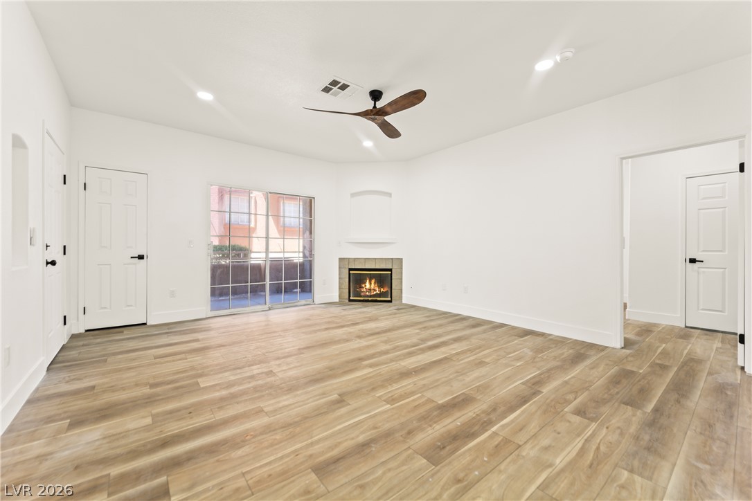 4730 East Craig Road, Unit 1053 Las Vegas, NV 89115 - Photo 3 of 32 A spacious living area features elegant hardwood flooring and a cozy fireplace, perfect for relaxation.