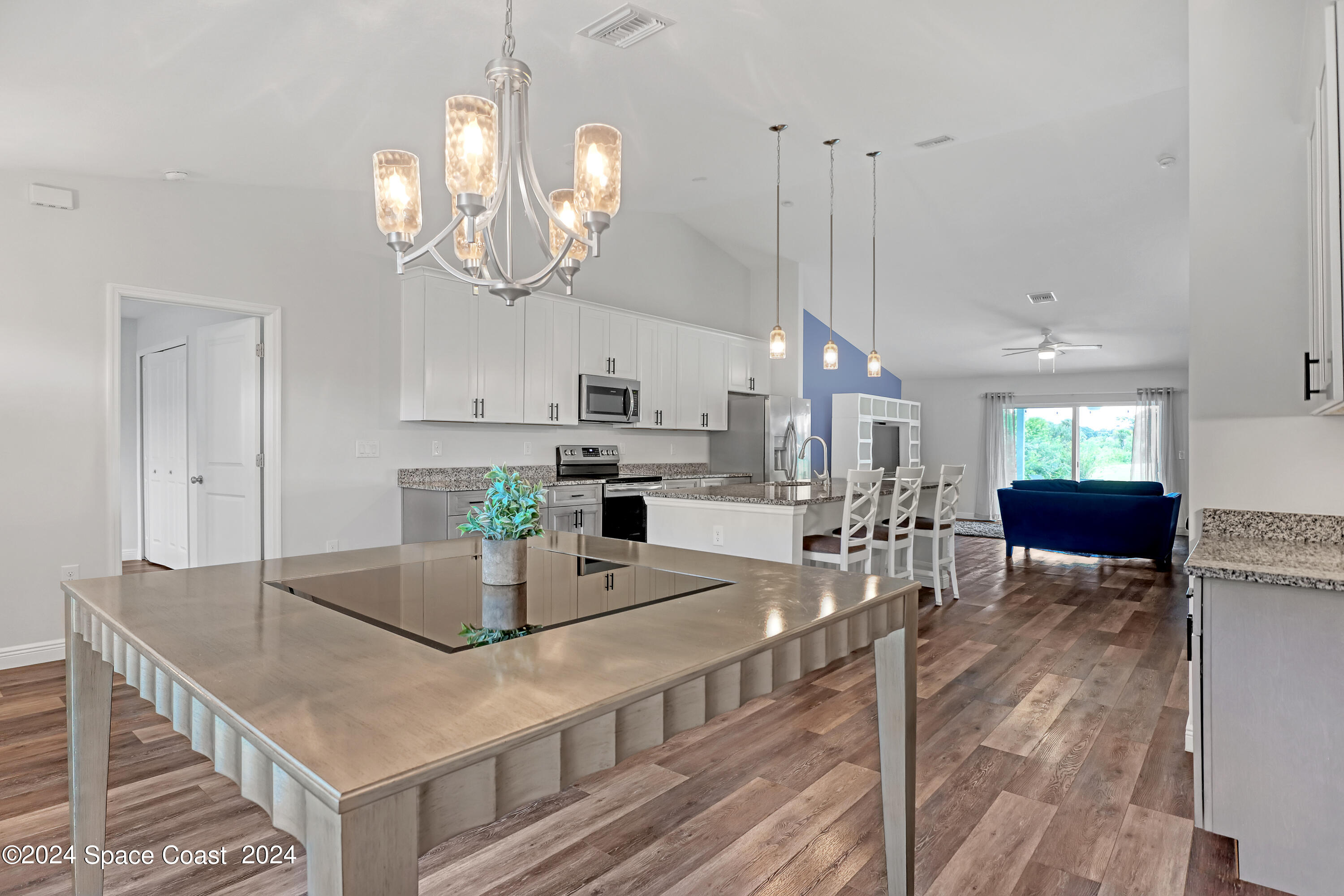 4383 Prentice Lane Mims, FL 32754 - Photo 13 of 48 a kitchen with kitchen island granite countertop a table chairs sink and cabinets