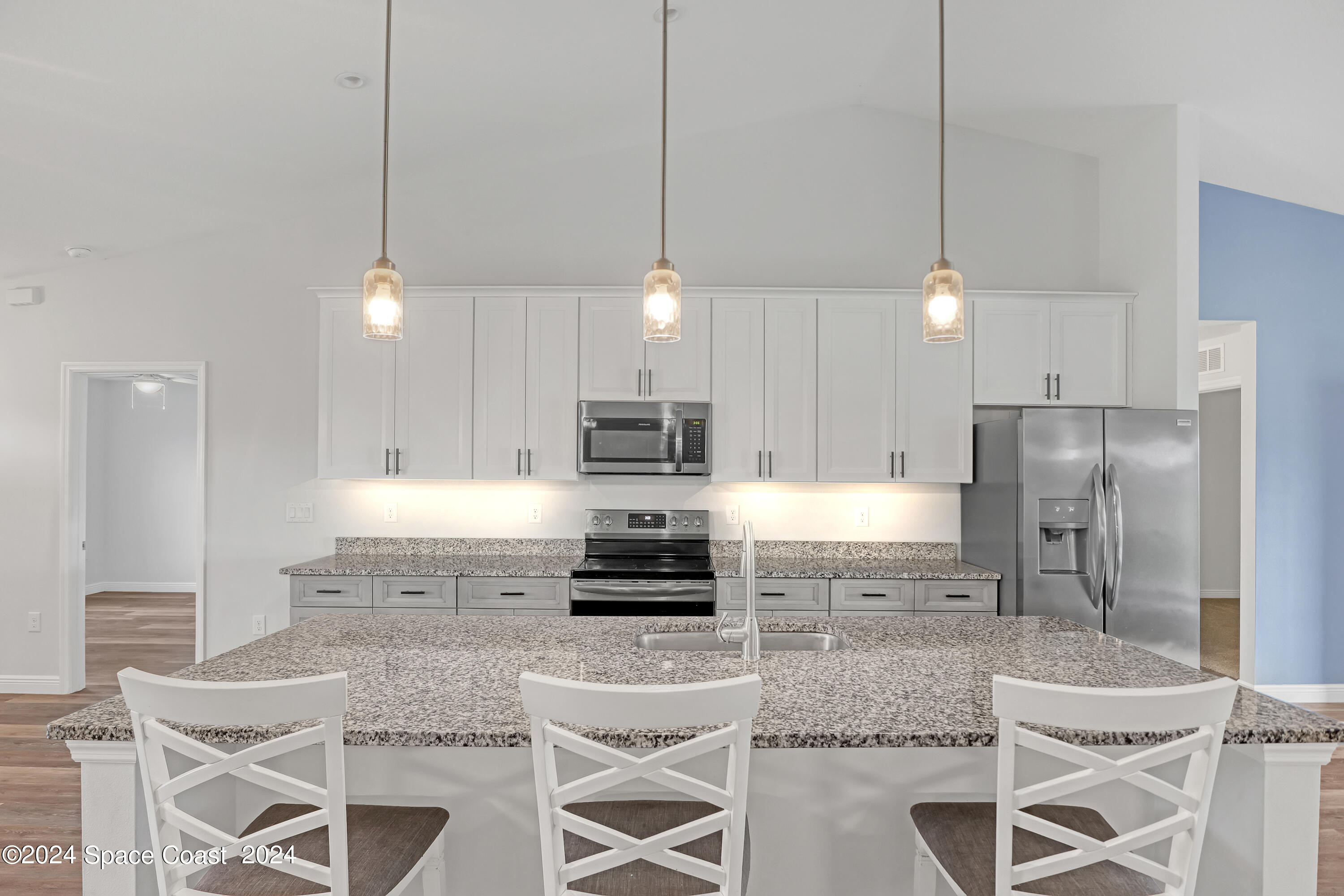 4383 Prentice Lane Mims, FL 32754 - Photo 16 of 48 a kitchen with kitchen island granite countertop a refrigerator a stove a oven a sink a dining table and chairs with wooden floor