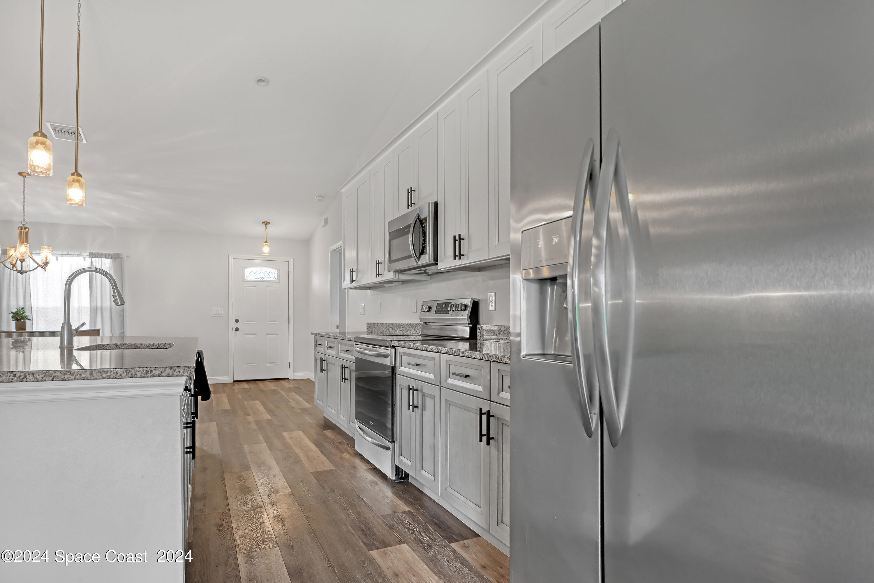 4383 Prentice Lane Mims, FL 32754 - Photo 17 of 48 a kitchen with stainless steel appliances granite countertop a sink stove and refrigerator