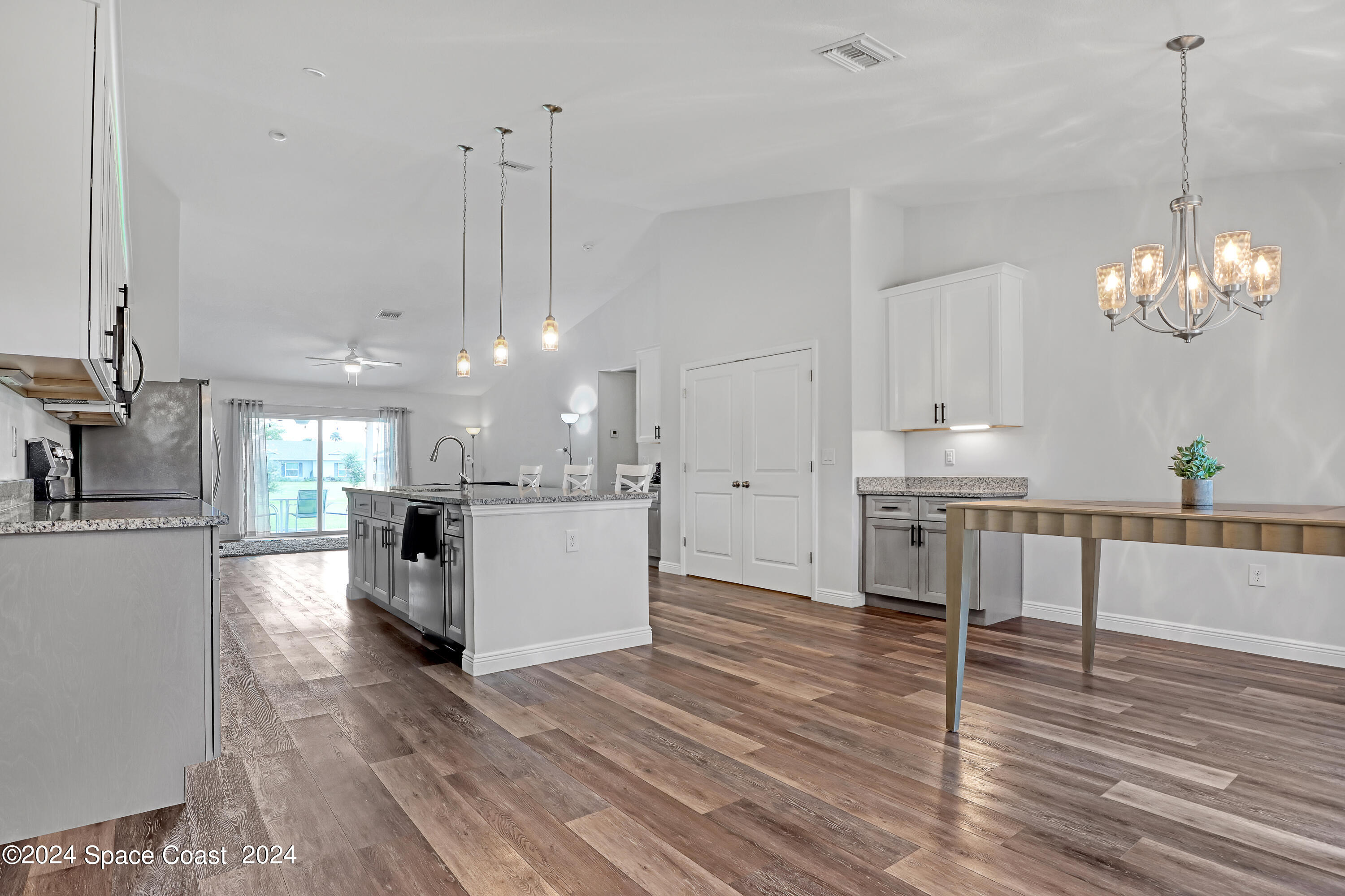 4383 Prentice Lane Mims, FL 32754 - Photo 10 of 48 a view of a kitchen with dining table chairs wooden floor and a chandelier