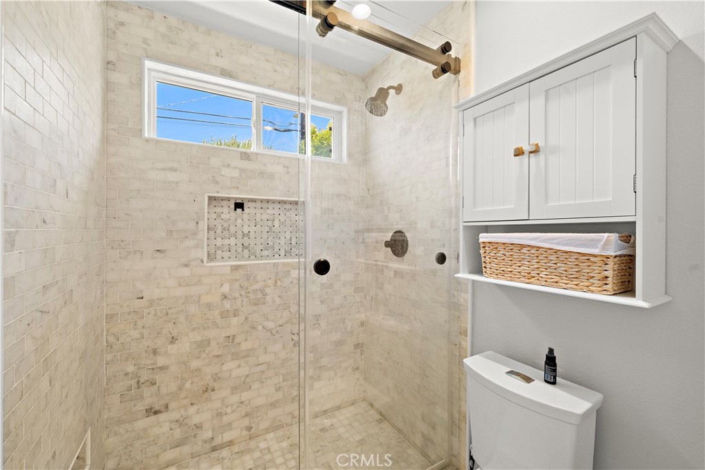 8741 La Roca Avenue Fountain Valley, CA 92708 - Photo 26 of 50 Pocket door opens to the walk-in shower with designer tile surround and clear glass enclosure