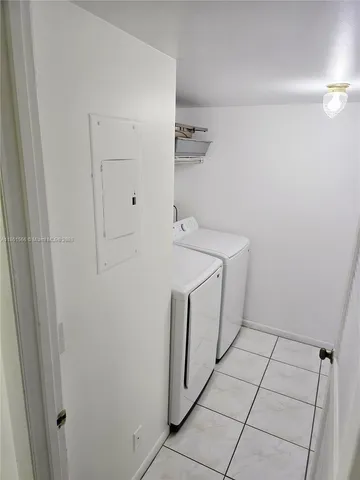a utility room with cabinets washer and dryer