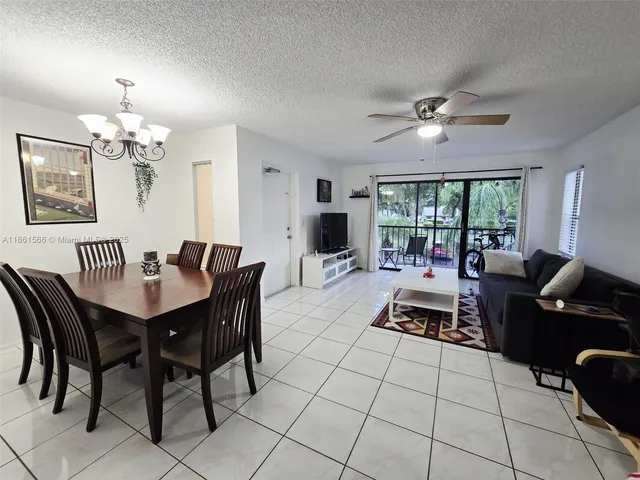 a living room with furniture a chandelier and a table