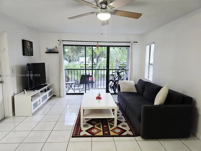 a living room with patio furniture and a flat screen tv