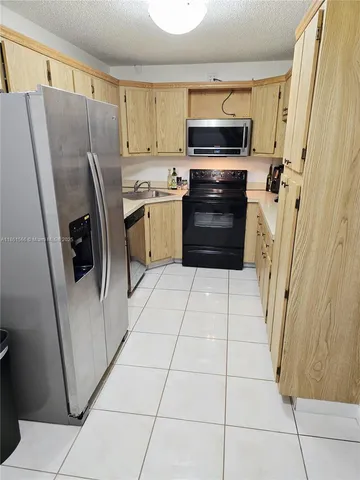 a kitchen with stainless steel appliances a refrigerator sink and microwave
