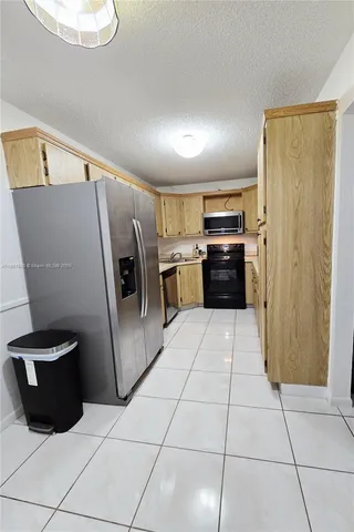 a kitchen with granite countertop a refrigerator and a sink