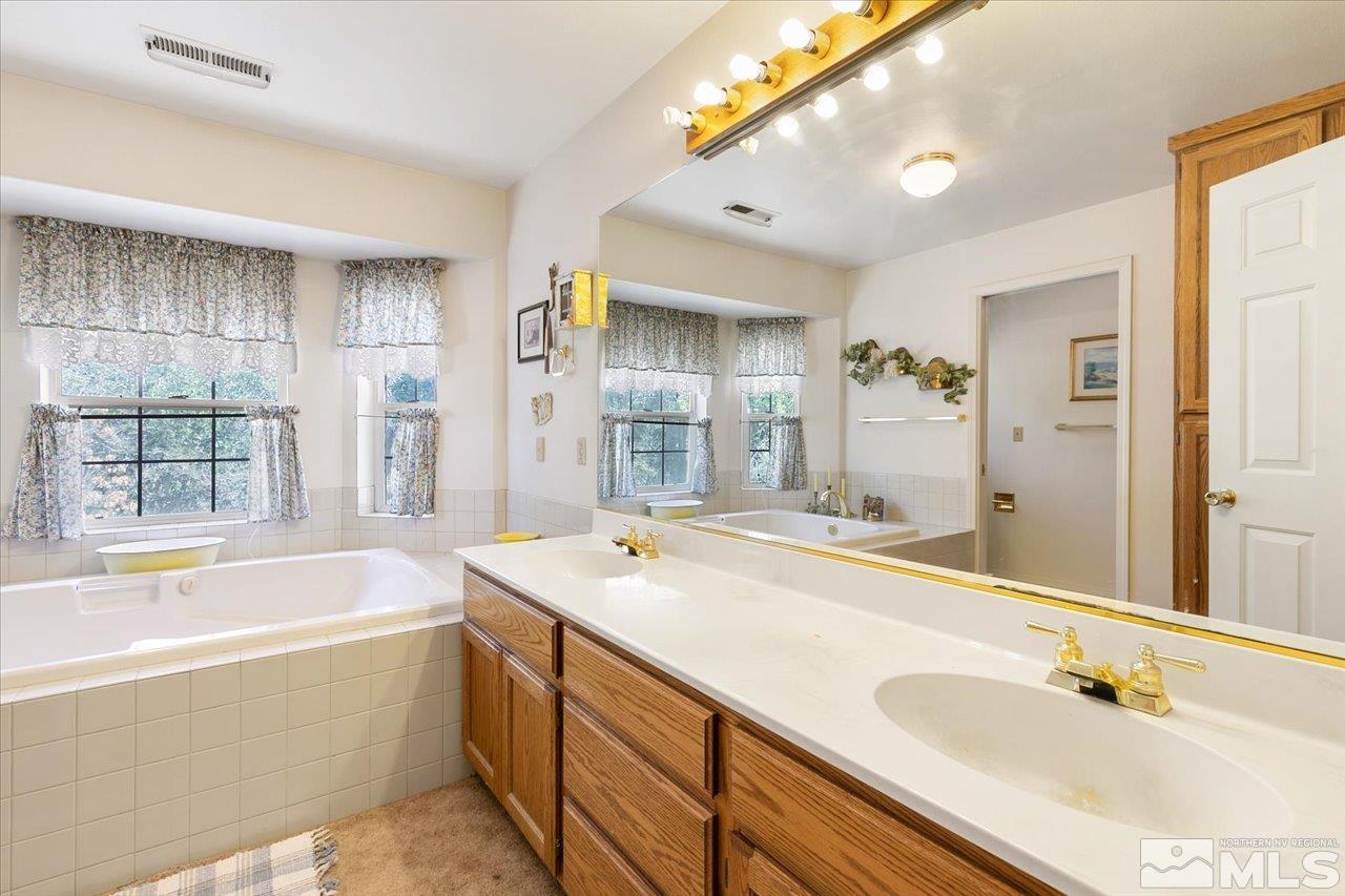 5790 Hooper Place Fallon, NV 89406 - Photo 30 of 39 a bathroom with a tub sink and mirror