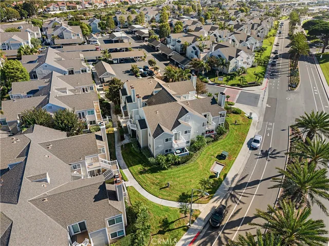 an aerial view of a residential houses with outdoor space and a car park