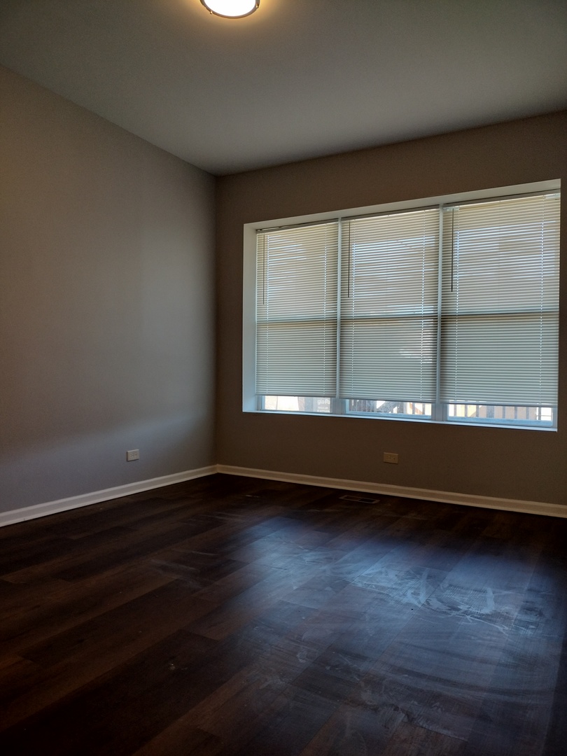 5725 South Green Street, Unit 1 Chicago, IL 60621 - Photo 13 of 18 a view of an empty room with wooden floor and a window
