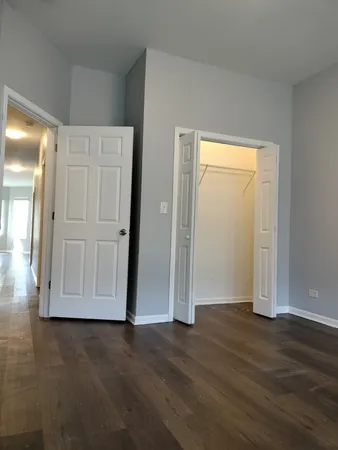 an empty room with wooden floor and closet area