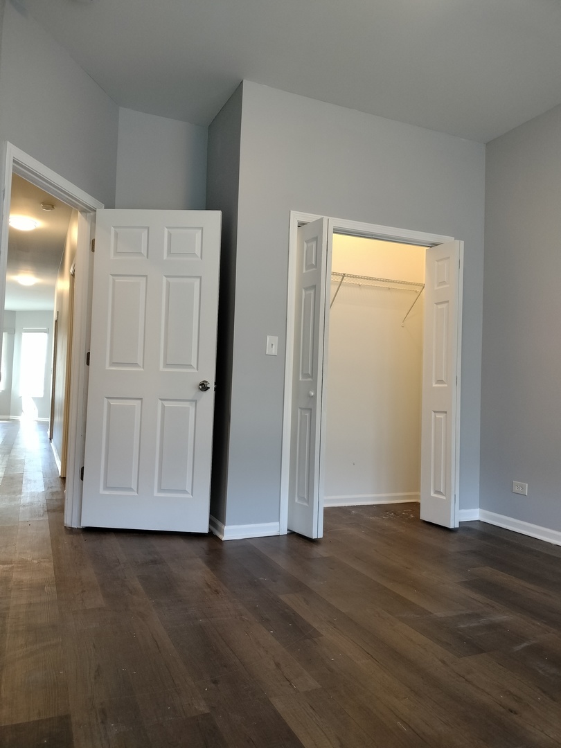 5725 South Green Street, Unit 1 Chicago, IL 60621 - Photo 14 of 18 an empty room with wooden floor and closet area