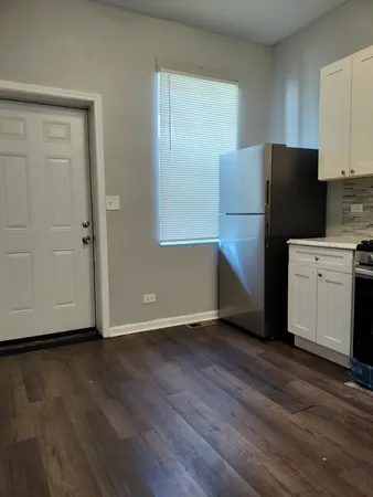 a kitchen with a refrigerator and a stove top oven