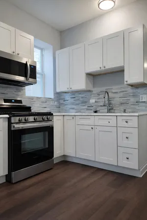 a kitchen with granite countertop wooden cabinets stainless steel appliances and sink