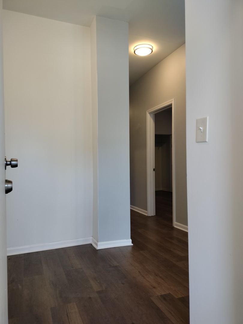 5725 South Green Street, Unit 1 Chicago, IL 60621 - Photo 2 of 18 an empty room with wooden floor and closet