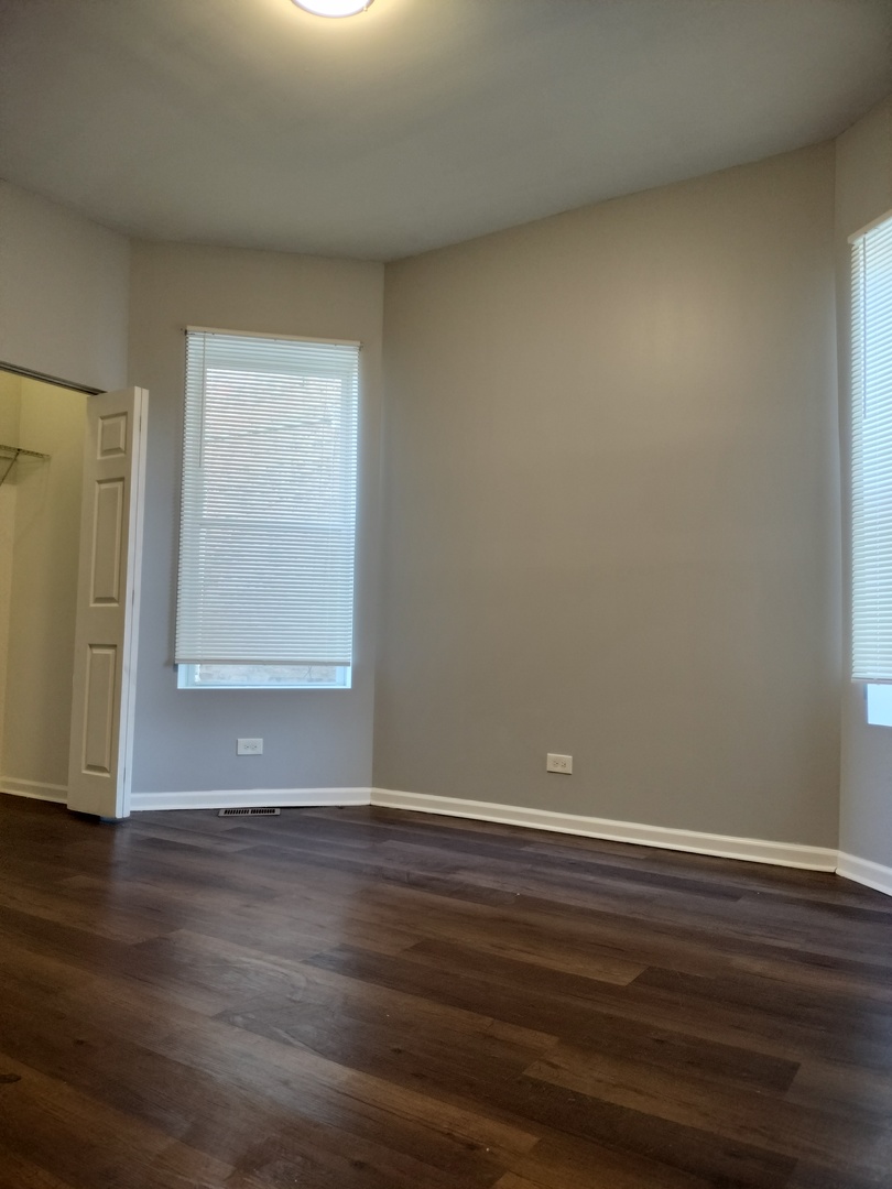 5725 South Green Street, Unit 1 Chicago, IL 60621 - Photo 6 of 18 a view of an empty room with wooden floor and a window