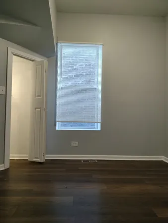 a view of a small space with wooden floor and a window