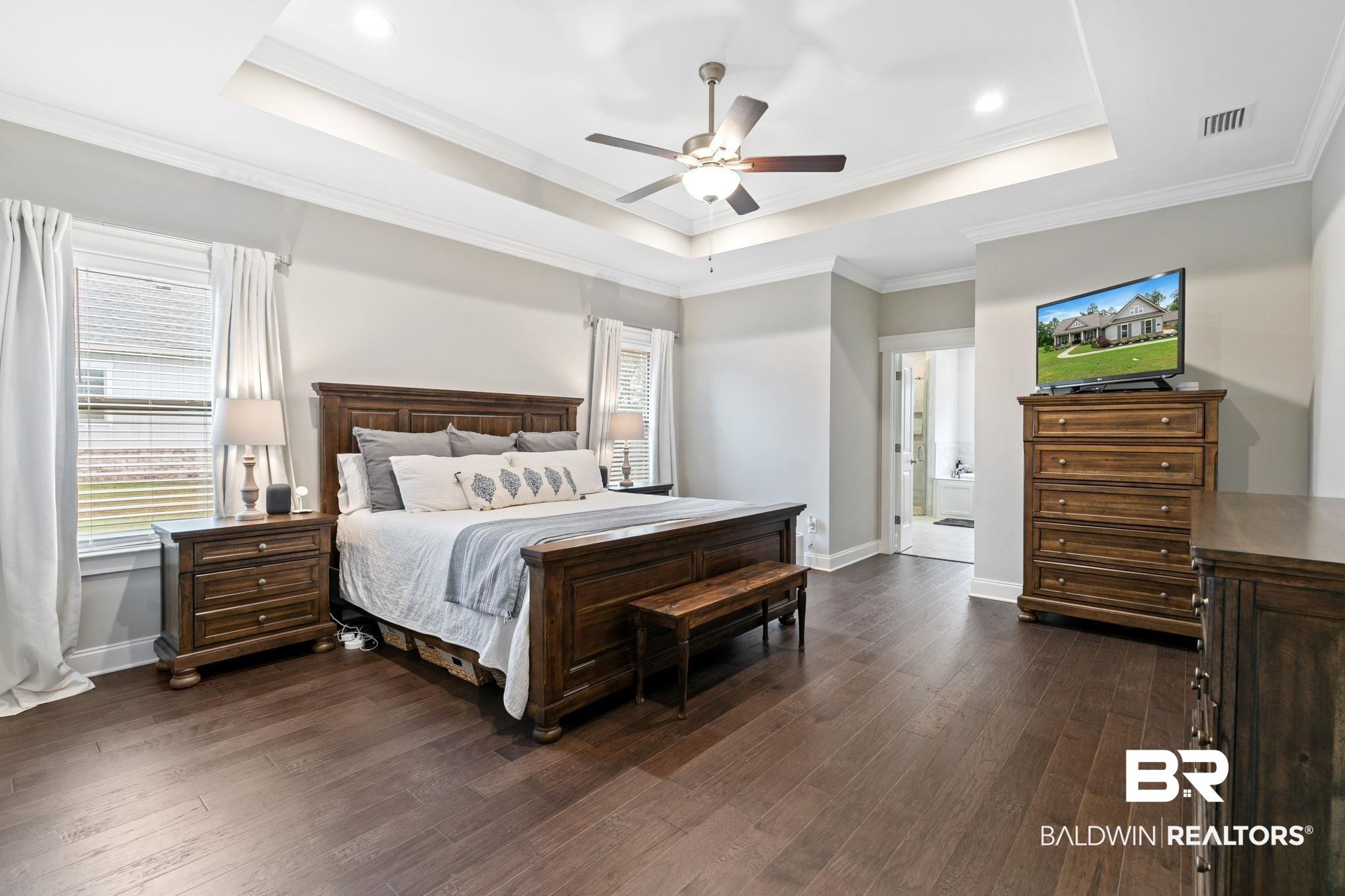 13233 Ibis Boulevard Daphne, AL 36527 - Photo 25 of 100 Spacious bedroom featuring rich wood-finish flooring, a tray ceiling with a ceiling fan, and crown molding