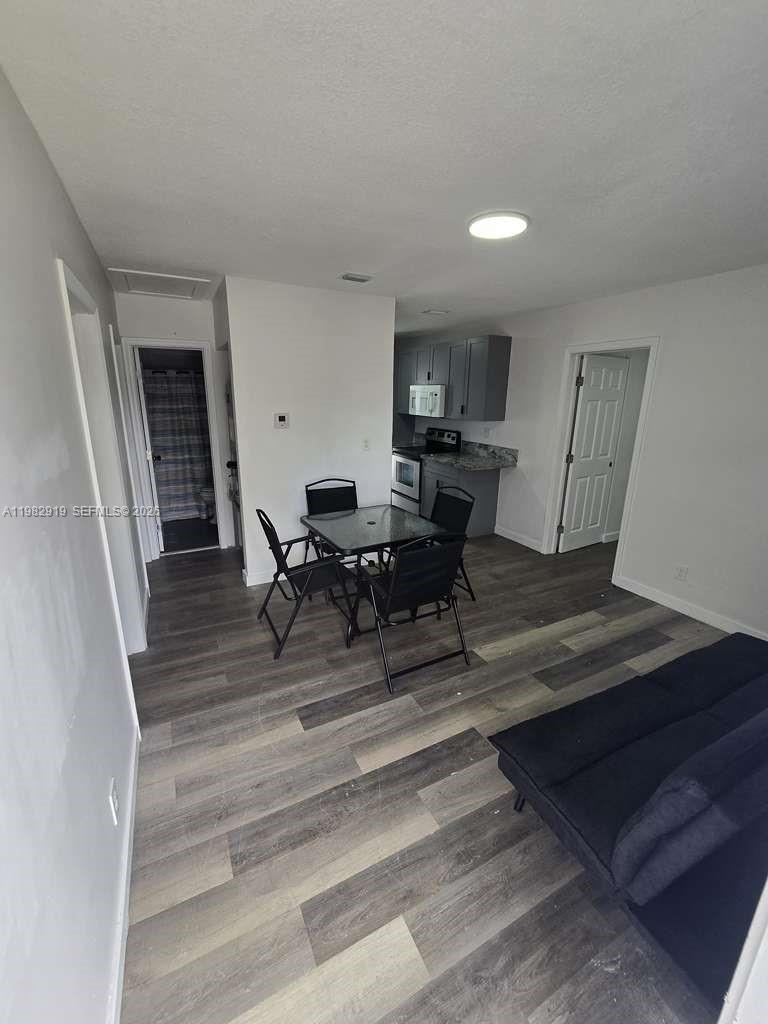 26633 Southwest 138th Court, Unit 1 Homestead, FL 33032 - Photo 4 of 8 a view of a workspace with furniture window and wooden floor