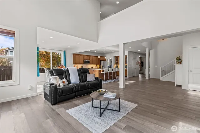 a living room with furniture a wooden floor and a large window