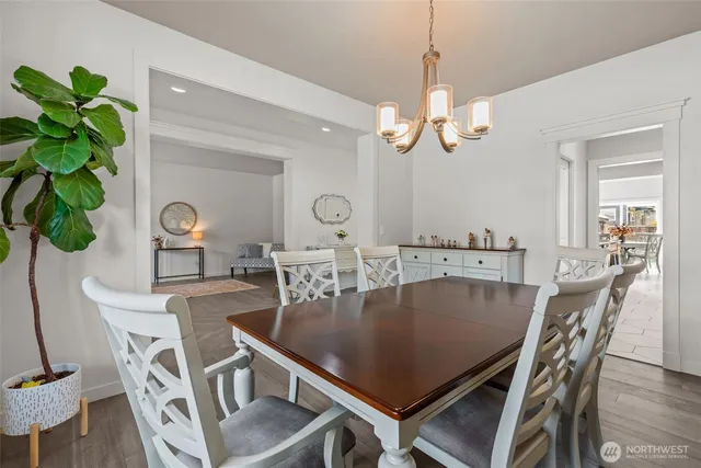 a view of a dining room with furniture a chandelier and wooden floor