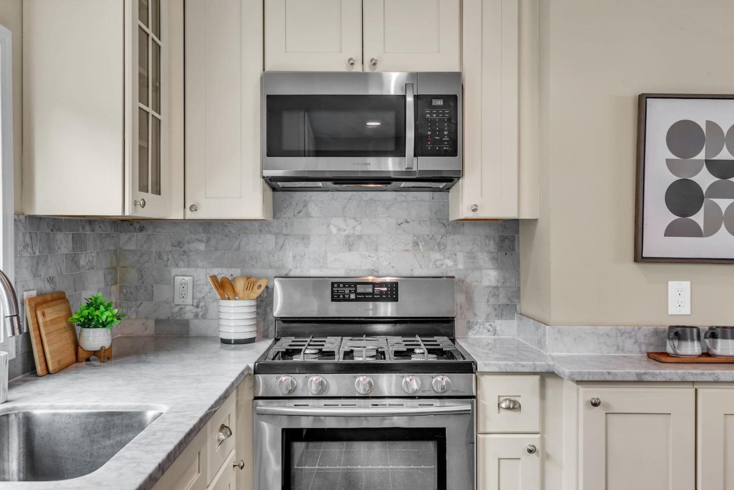 363 Pacific Avenue Pacifica, CA 94044 - Photo 17 of 70 a kitchen with stainless steel appliances granite countertop a sink a stove a microwave and cabinets