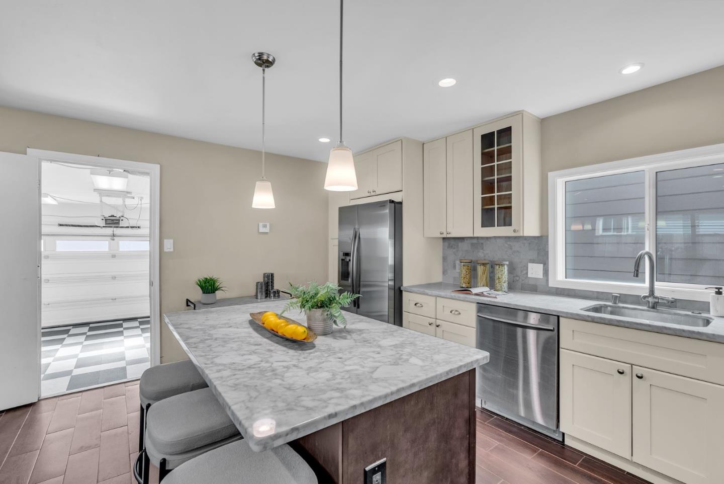 363 Pacific Avenue Pacifica, CA 94044 - Photo 19 of 70 a kitchen with stainless steel appliances granite countertop a stove a sink a dining table and chairs with wooden floor
