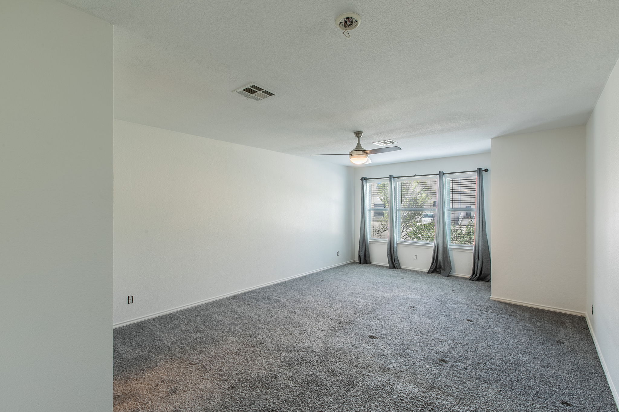 157 Lex Word Kyle, TX 78640 - Photo 15 of 34 Plush wall-to-wall carpeting and triple windows define this versatile living space.