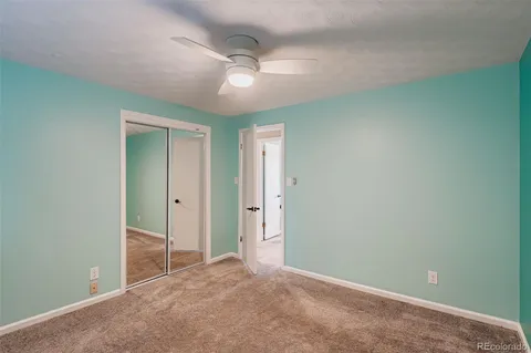 an empty room with closet and fan