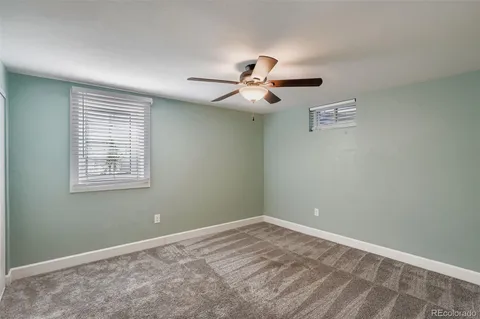 a view of a room with a ceiling fan and a window
