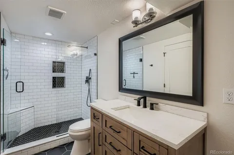 a bathroom with a sink a toilet and shower