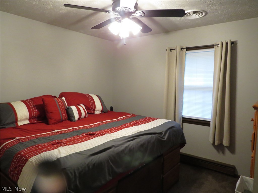 9811 Church Road Huron, OH 44839 - Photo 14 of 28 Bedroom with a textured ceiling, dark colored carpet, and ceiling fan
