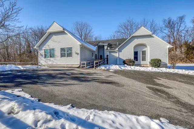 a front view of a house with a yard covered with snow