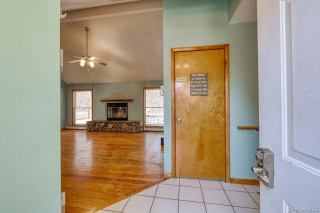 an empty room with wooden floor fireplace and windows