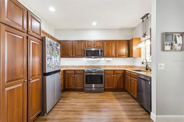 a kitchen with granite countertop stainless steel appliances and wooden cabinets