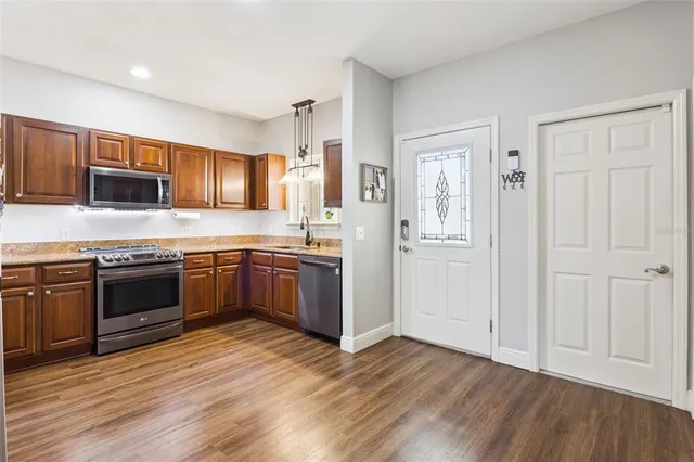 a kitchen with stainless steel appliances kitchen island granite countertop a stove a sink and a refrigerator
