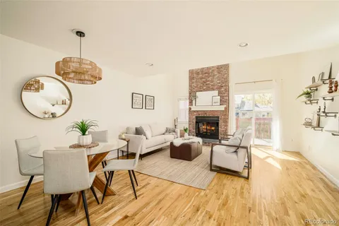a living room with furniture a fireplace and a floor to ceiling window