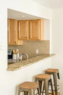 a kitchen with a table chairs in it and wooden cabinets