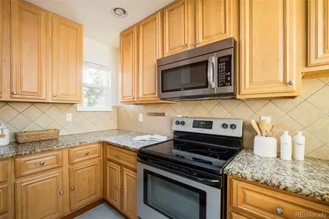 a kitchen with granite countertop white cabinets and appliances