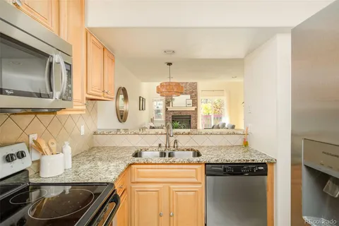 a kitchen with stainless steel appliances granite countertop a sink stove and cabinets