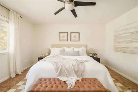 a bedroom with a bed and painting on the wall
